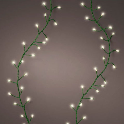 A string of micro LED lights with a warm white bulb and green wire, displaying a flickering effect against a dark background.